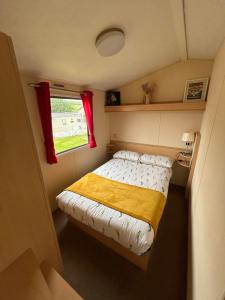 a small bedroom with a bed and a window at Newquay buy resort Holiday in Newquay Bay Resort