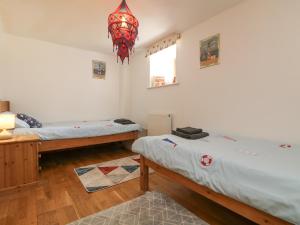 a room with two beds and a chandelier at Mill in Porthleven