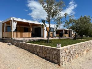 eine steinerne Stützmauer vor einem Haus in der Unterkunft Vila Olson - Holiday Village Twins in Pakoštane
