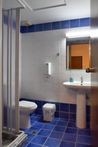 a blue and white bathroom with a toilet and a sink at Akatos Hotel in Agia Marina Nea Kydonias