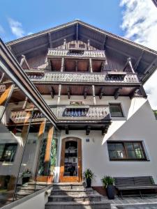 a house with a wooden roof and stairs at Hotel-Pension Hoferhaus in Neukirchen am Großvenediger