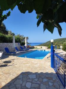 uma piscina com cadeiras e o oceano ao fundo em Private Cottage in Stavros em Marantochori