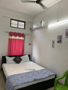 Schlafzimmer mit einem Bett und einem roten Fenster in der Unterkunft JP Hotel in Tezpur