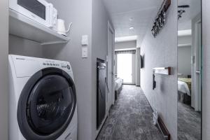 a washing machine in a room with a hallway at Tokyu Stay Osaka Hommachi in Osaka