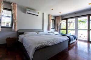 sypialnia z dużym łóżkiem w pokoju z oknami w obiekcie F4 Beach house Kitchen BBQ 3 bedrooms Large yard w mieście Rayong