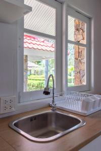 eine Küche mit Spüle und zwei Fenstern in der Unterkunft F4 Beach house Kitchen BBQ 3 bedrooms Large yard in Rayong