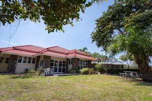 ein Haus mit einem roten Dach und einem Hof in der Unterkunft F4 Beach house Kitchen BBQ 3 bedrooms Large yard in Rayong