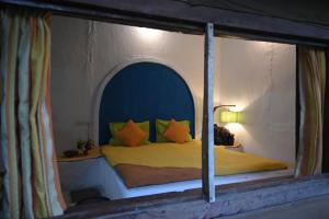 a bedroom with a bed with a blue head board at Bastar Birds Nest 