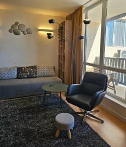 ein Wohnzimmer mit einem Sofa, einem Stuhl und einem Tisch in der Unterkunft Трехкомнатный апартамент с видом на море in Aheloy