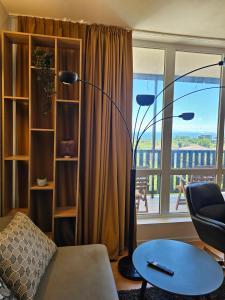 ein Wohnzimmer mit einer Stehlampe und einem Fenster in der Unterkunft Трехкомнатный апартамент с видом на море in Aheloy