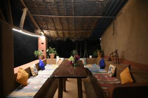 a long table in a room with blue and yellow pillows at Bastar Birds Nest 