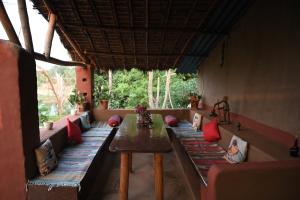 a room with couches and a table with red pillows at Bastar Birds Nest 