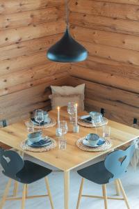 Una mesa de madera con dos sillas y una lámpara negra. en Hütte am Wald, en Hof bei Salzburg