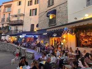 a group of people sitting at tables outside a restaurant at Bateau plaisance hotel Antibes in Antibes