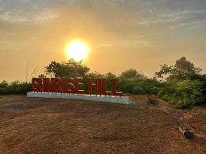 a bench in a field with the sunset in the background at Country View Inn in Sungai Lembing