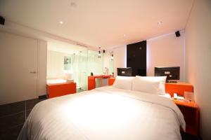 a bedroom with a large white bed and two monitors at Jongno Hotel Pop Leeds Premier in Seoul