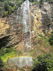 a waterfall with a rainbow in front of it at Country View Inn in Sungai Lembing