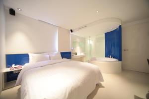 1 dormitorio con 1 cama blanca grande y baño en Jongno Hotel Pop Leeds Premier en Seúl