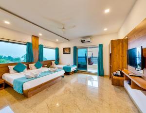 ein Schlafzimmer mit einem großen Bett und einem TV in der Unterkunft Hotel Mahabaleshwar Fragrance in Mahabaleshwar