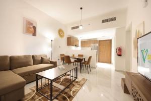 a living room with a couch and a table at Silk Valley - Modern 1br Pool And Gym Balcony in Al Qurayyah