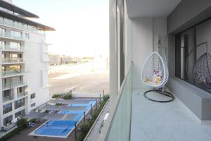 a balcony with a chair on a building at Silk Valley - Modern 1br Pool And Gym Balcony in Al Qurayyah