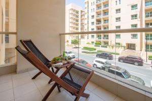 a balcony with a chair and a view of a street at Frank Porter - Al Thayyal 2, The Greens in Dubai