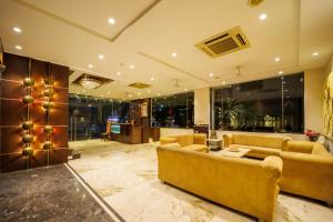a large living room with couches and a table at Hotel Celebration in Jamnagar