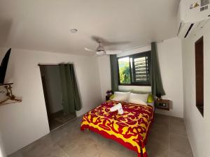 um pequeno quarto com uma cama e uma janela em MOOREA CHILL and BEACH LODGE em Teavaro