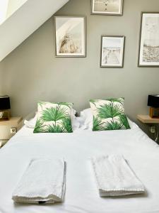 a bedroom with a white bed with two towels on it at Escapade marine in Deauville