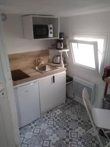 a small kitchen with a sink and a window at STUDIO PORT MIOU terrasse proximité mer - Calanques in Marseille