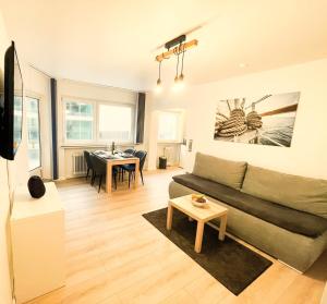 ein Wohnzimmer mit einem Sofa und einem Tisch in der Unterkunft Ambiente Apartment in Bremen