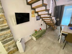 uma sala de estar com uma escada e uma televisão na parede em Loft Nineteen Apartment em La Spezia