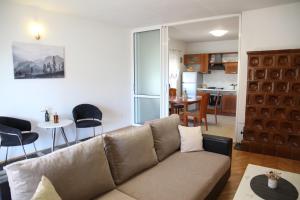 ein Wohnzimmer mit einem Sofa und einer Küche in der Unterkunft Apartments Kresan in Zadar