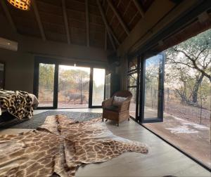 1 dormitorio con una alfombra de jirafa en el suelo en Simba Safaris African Pride Exotic Lodge en Lephalale