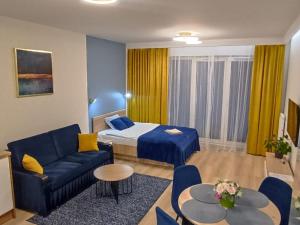 Habitación de hotel con cama y sofá azul en Apartament Centrum Białystok, en Białystok