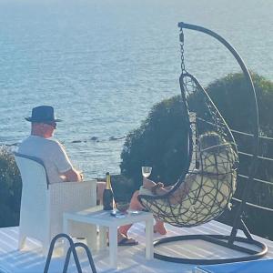 Ein Mann, der auf einem Stuhl mit einem Glas Wein sitzt. in der Unterkunft Locazione Turistica Il Tucano in Agrigento