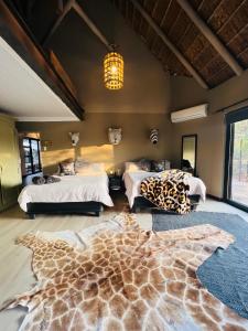 1 dormitorio con 2 camas y una alfombra de jirafa en el suelo en Simba Safaris African Pride Exotic Lodge en Lephalale