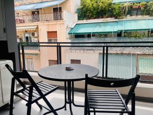 stół i 2 krzesła na balkonie ze stołem w obiekcie Elvita Apartments 4 w Atenach