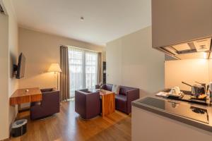 a kitchen and living room with chairs and a table at Pakat Suites in Vienna