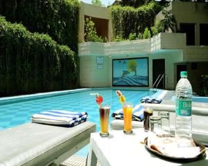 uma mesa com bebidas junto a uma piscina em Rajdarshan - A Lake View Hotel in Udaipur em Udaipur