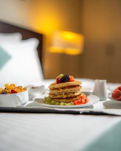 a table with a plate of pancakes and fruit at The Parisian Hotel in Beirut