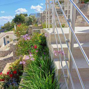 un conjunto de escaleras con flores en Living Castro Apartments, en Castro di Lecce