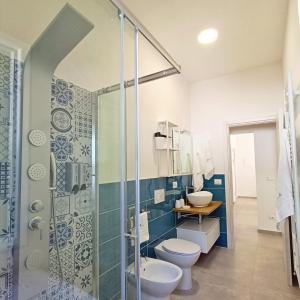 y baño con aseo y ducha acristalada. en Living Castro Apartments, en Castro di Lecce