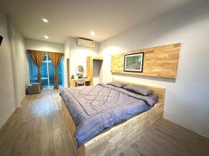 a bedroom with a large bed in a room at บ้านไร่ดอกแก้ว in Chom Bung