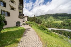 a walkway next to a building on a hill at Studio Chasa Muschna, Vulpera in Vulpera