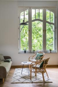 a living room with a table and chairs and windows at Stafétaház Apartmanok in Vác