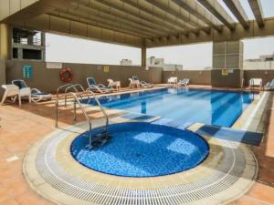 una gran piscina con una gran piscina azul en Ruby Residence- Cozy 1BHK Apartment with Balcony in Silicon Oasis, en Dubái
