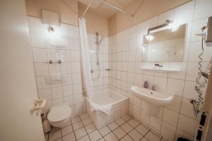 a white bathroom with a toilet and a sink at guestified LIYANA in Ratingen