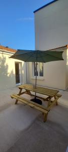 a picnic table with an umbrella on top of it at La maisonnette cherbourgeoise in Cherbourg en Cotentin