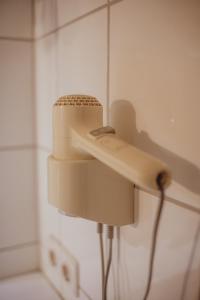 a hair dryer on the wall of a bathroom at guestified LIYANA in Ratingen